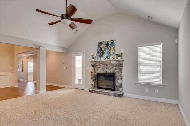 unfurnished living room with visible vents, carpet, a fireplace, high vaulted ceiling, and a ceiling fan