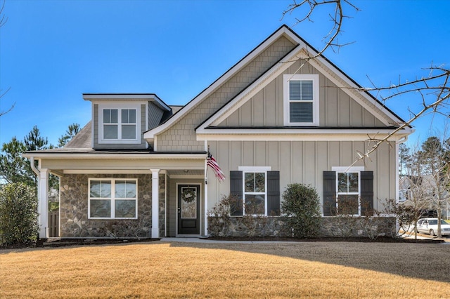 craftsman inspired home with stone siding, board and batten siding, and a front yard