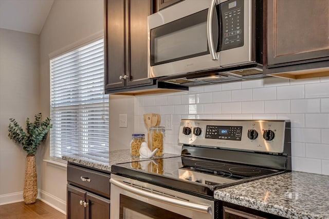 kitchen featuring dark brown cabinets, light wood-style flooring, appliances with stainless steel finishes, and baseboards