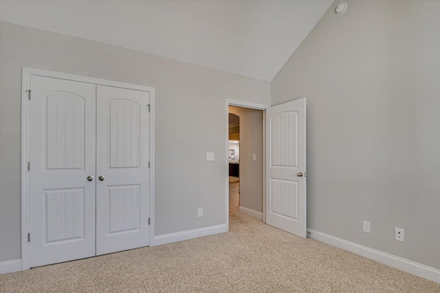 unfurnished bedroom with vaulted ceiling, baseboards, a closet, and carpet floors