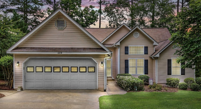 view of front of house featuring a garage and a lawn