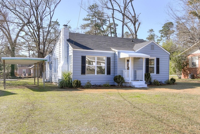 view of front facade featuring a shingled roof, a front yard, and a chimney