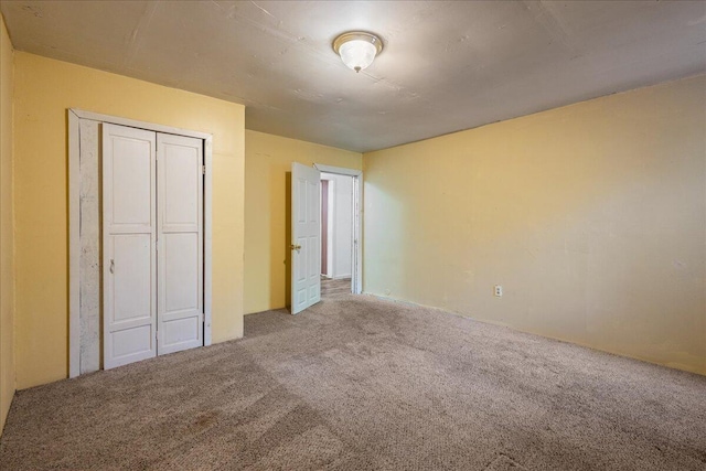 unfurnished bedroom featuring light colored carpet and a closet