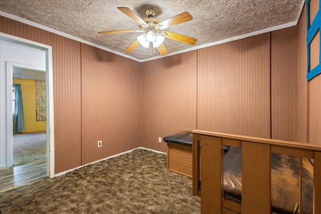 unfurnished office with ceiling fan, ornamental molding, carpet, and a textured ceiling