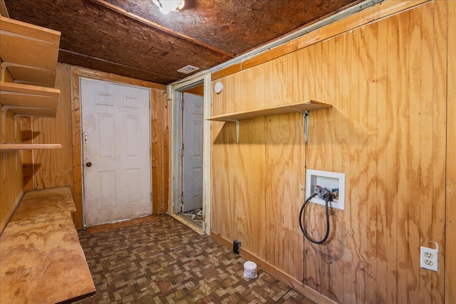 laundry area featuring dark parquet flooring, washer hookup, and wood walls