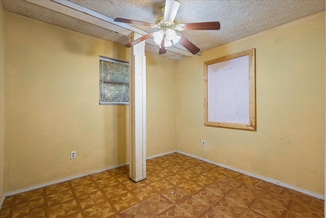 empty room with ceiling fan, parquet flooring, and a textured ceiling