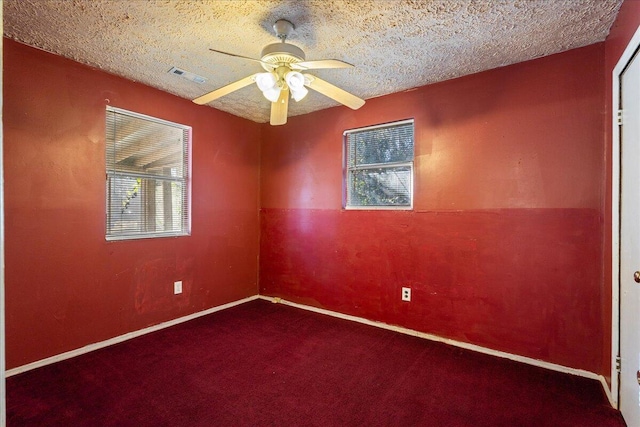 carpeted empty room featuring ceiling fan and a textured ceiling