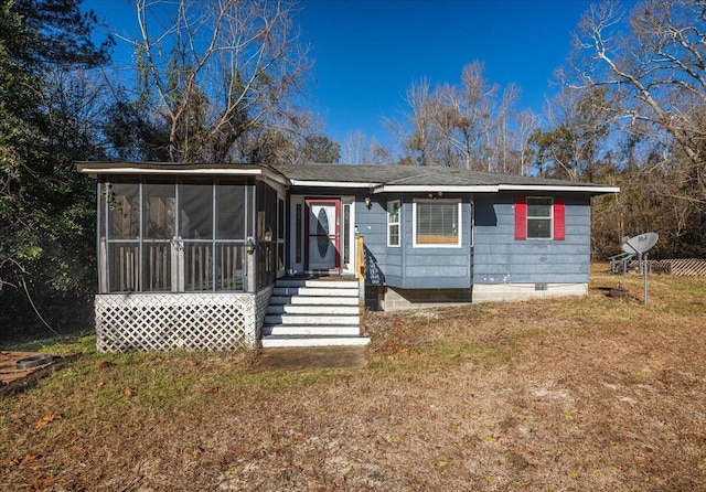 view of front facade featuring a sunroom and a front lawn