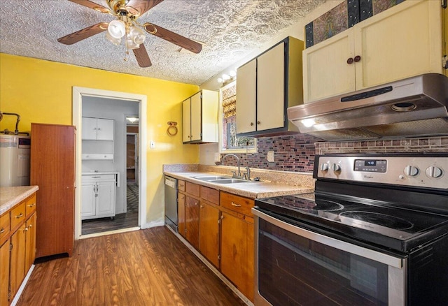 kitchen featuring sink, a textured ceiling, appliances with stainless steel finishes, dark hardwood / wood-style floors, and electric water heater