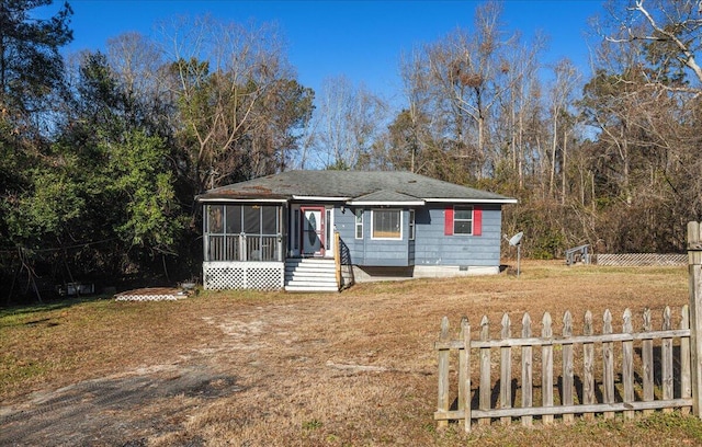 view of front of property with a sunroom and a front yard