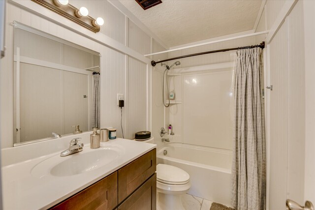 bathroom with tile patterned flooring, shower / bath combo, vanity, toilet, and a textured ceiling