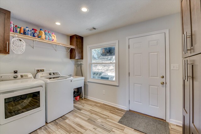 washroom featuring washing machine and clothes dryer, cabinet space, recessed lighting, baseboards, and visible vents