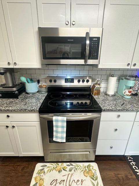 kitchen featuring white cabinetry, light stone counters, tasteful backsplash, and appliances with stainless steel finishes