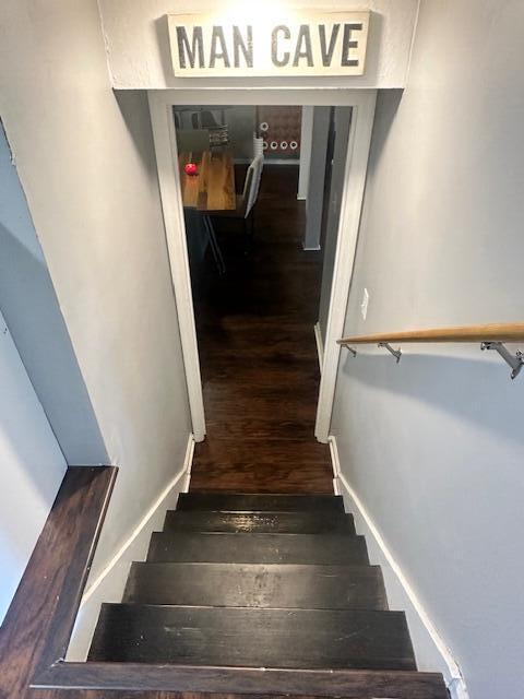 staircase featuring baseboards and wood finished floors