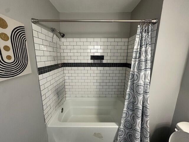 full bathroom featuring toilet and shower / tub combo