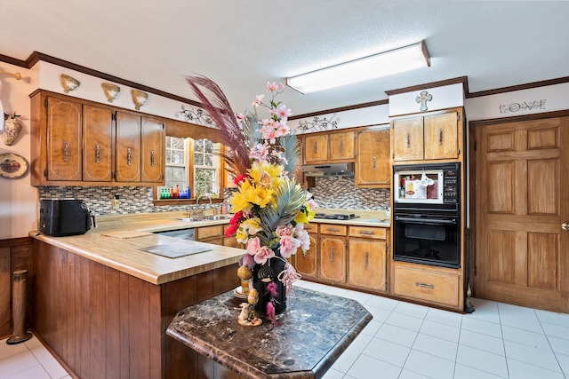 kitchen featuring a sink, a peninsula, brown cabinets, and built in microwave