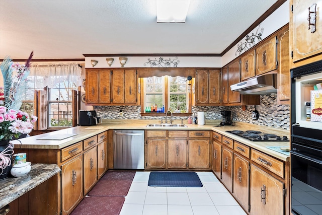 kitchen with light countertops, stainless steel dishwasher, a sink, and under cabinet range hood