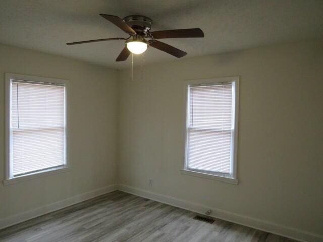 unfurnished room with light hardwood / wood-style flooring and ceiling fan