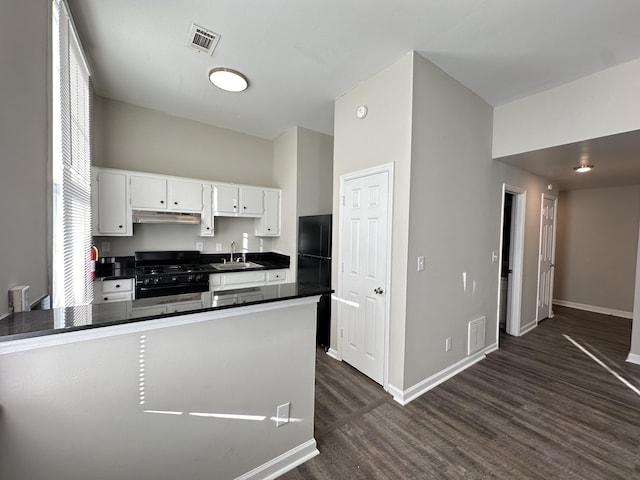 kitchen featuring dark wood-type flooring, black appliances, sink, kitchen peninsula, and white cabinetry