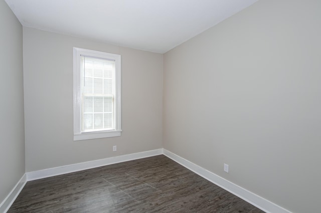 spare room featuring plenty of natural light and dark hardwood / wood-style floors