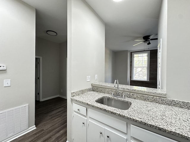 kitchen with light stone countertops, ceiling fan, sink, dark hardwood / wood-style floors, and white cabinetry