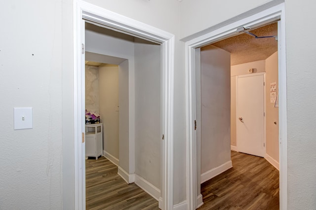 hallway featuring a textured ceiling and dark hardwood / wood-style flooring