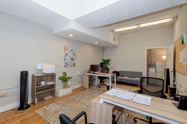 office space with a textured ceiling and light hardwood / wood-style flooring