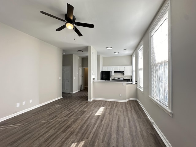 unfurnished living room featuring ceiling fan and dark hardwood / wood-style floors