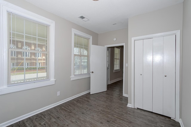 unfurnished bedroom featuring dark hardwood / wood-style floors and a closet