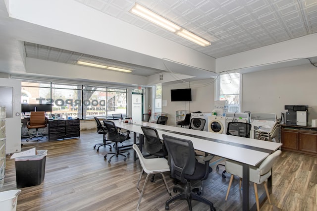 home office with washer and dryer and light hardwood / wood-style floors