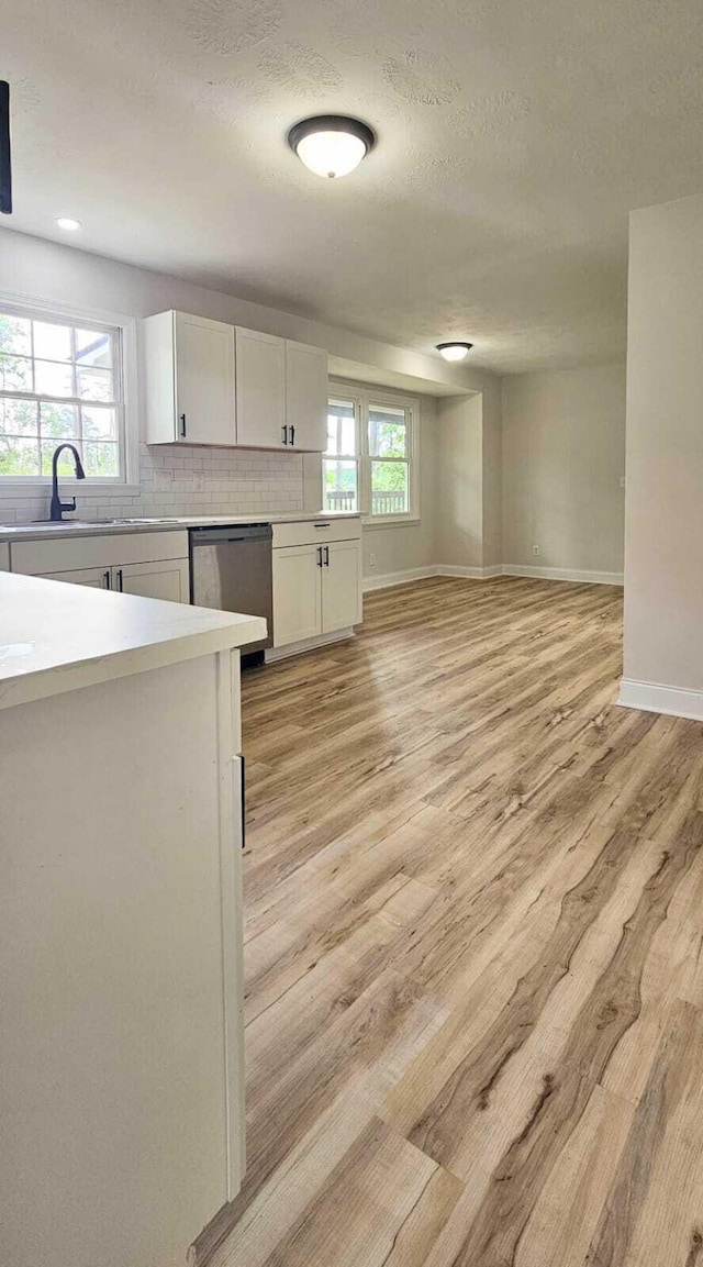 1306 Dominica Dr, Augusta, GA 30909 - kitchen with stainless steel dishwasher, a sink, white cabinetry, light countertops, and light wood-style flooring