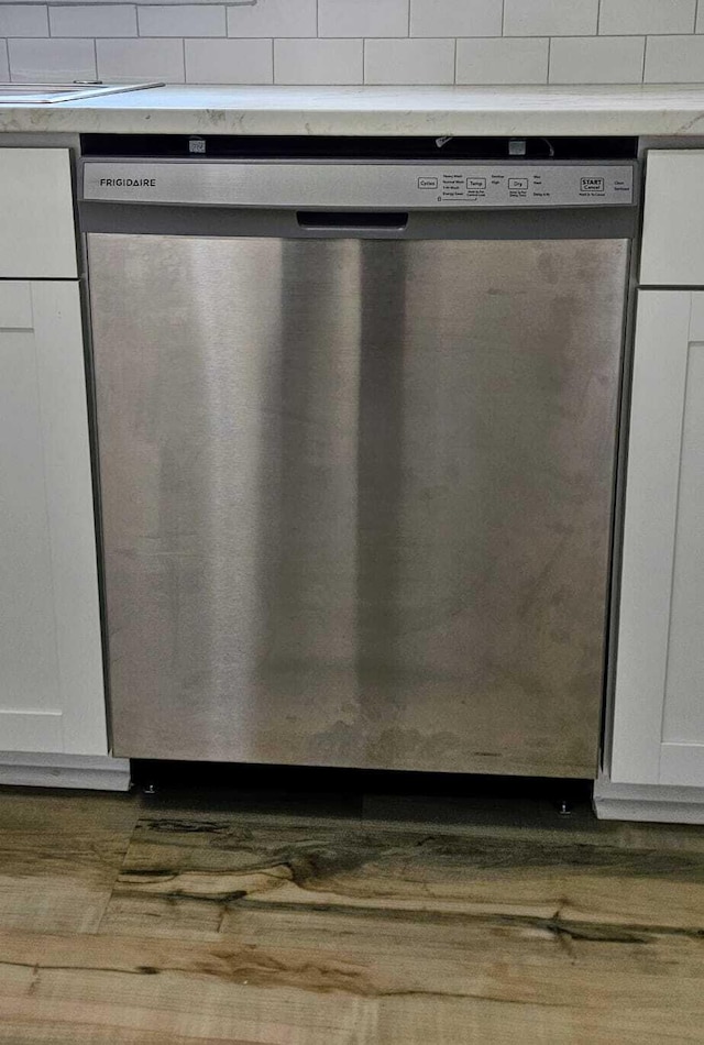 1306 Dominica Dr, Augusta, GA 30909 - detailed view of stainless steel dishwasher, white cabinets, wood finished floors, and light countertops