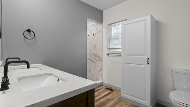 4593 Windsor Spring Rd, Hephzibah, GA 30815 - full bathroom with double vanity, a tile shower, and wood finished floors