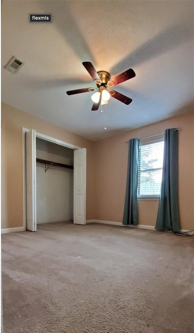 unfurnished bedroom with carpet, a textured ceiling, and ceiling fan