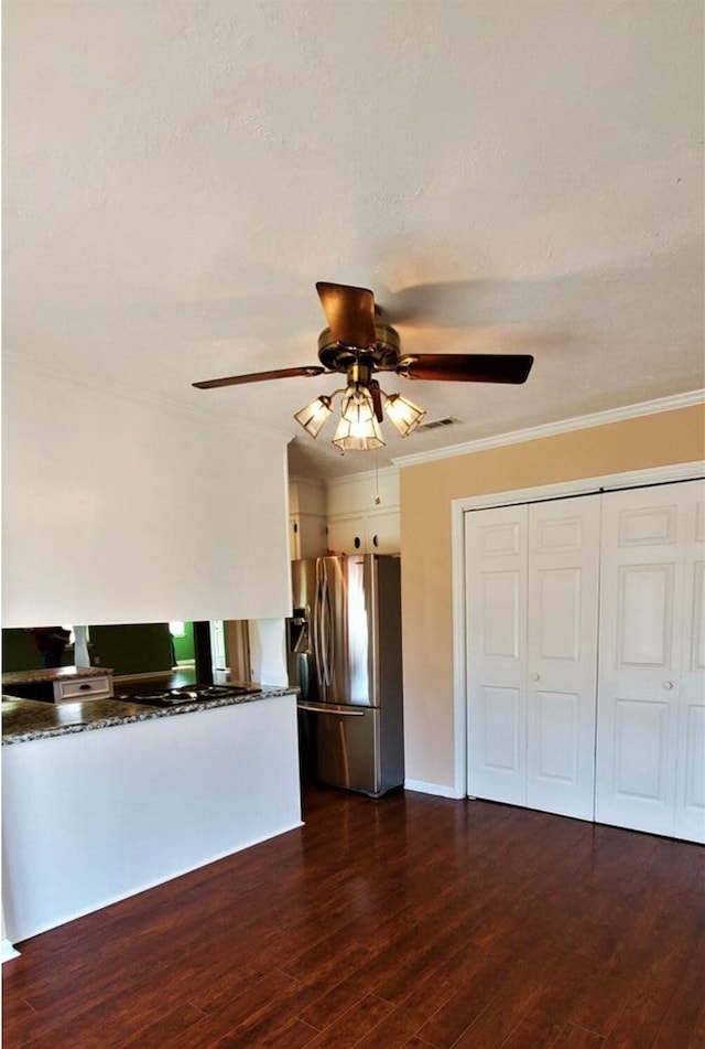 unfurnished living room featuring ceiling fan, dark hardwood / wood-style flooring, and crown molding