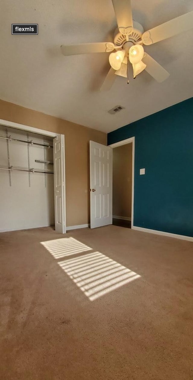 unfurnished bedroom with carpet flooring, a closet, and ceiling fan