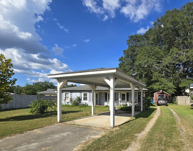 view of vehicle parking featuring a lawn and a carport