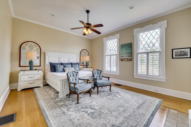 bedroom with visible vents, light wood-type flooring, and ornamental molding