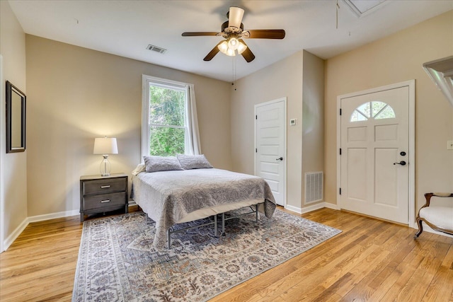 bedroom featuring visible vents, light wood-style flooring, and attic access