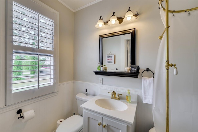 bathroom with vanity, wainscoting, crown molding, and toilet