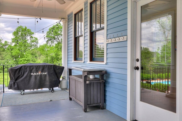 wooden deck featuring grilling area, covered porch, and a ceiling fan