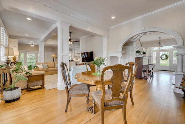 dining space with ornate columns, light wood-style floors, and a ceiling fan