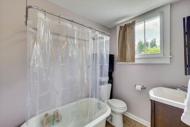 bathroom with toilet, shower / bath combo, vanity, and baseboards
