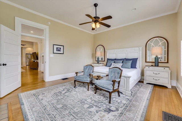 bedroom with light wood-style flooring, crown molding, baseboards, and visible vents