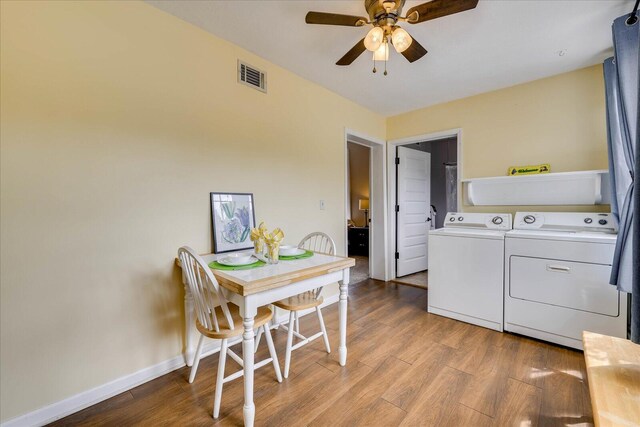 clothes washing area with visible vents, washer and clothes dryer, ceiling fan, and wood finished floors