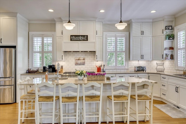 kitchen featuring white cabinetry, decorative backsplash, appliances with stainless steel finishes, and a wealth of natural light