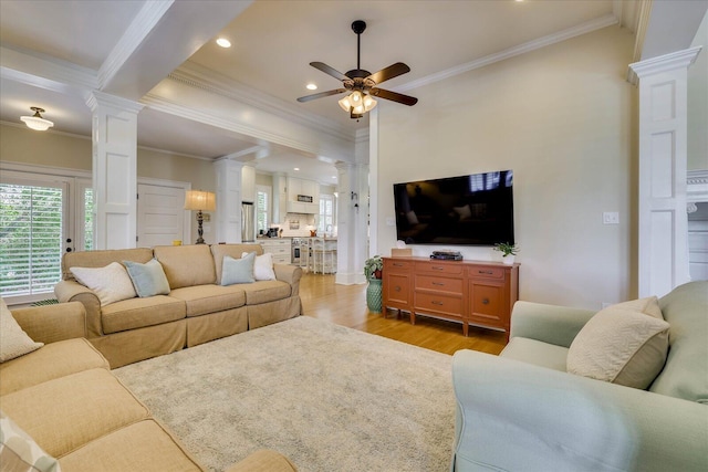 living room with light wood-style flooring, ornate columns, and ceiling fan