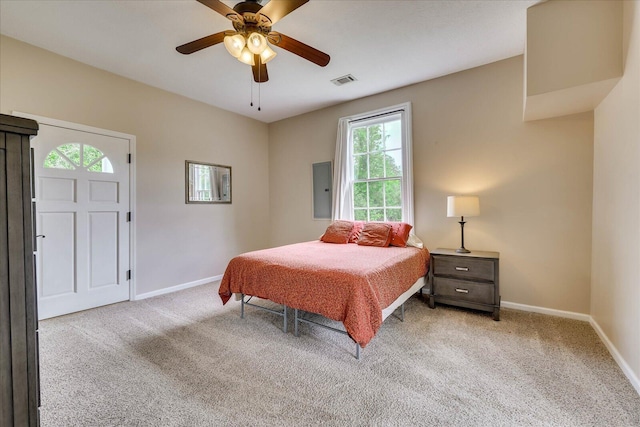 bedroom with visible vents, baseboards, light carpet, and electric panel