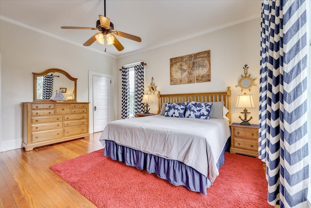 bedroom featuring light wood-style floors, multiple windows, crown molding, and a ceiling fan