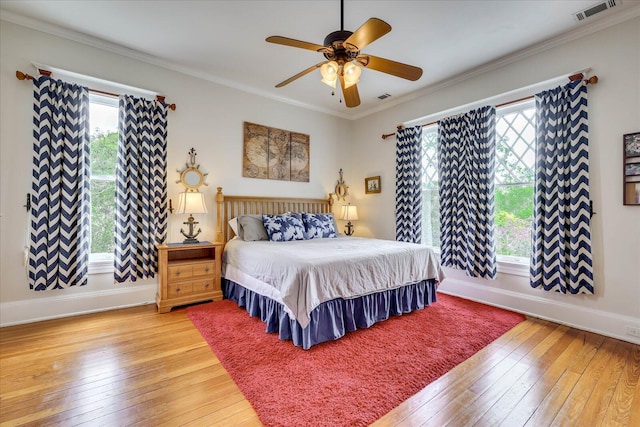 bedroom featuring visible vents, baseboards, light wood-type flooring, and multiple windows